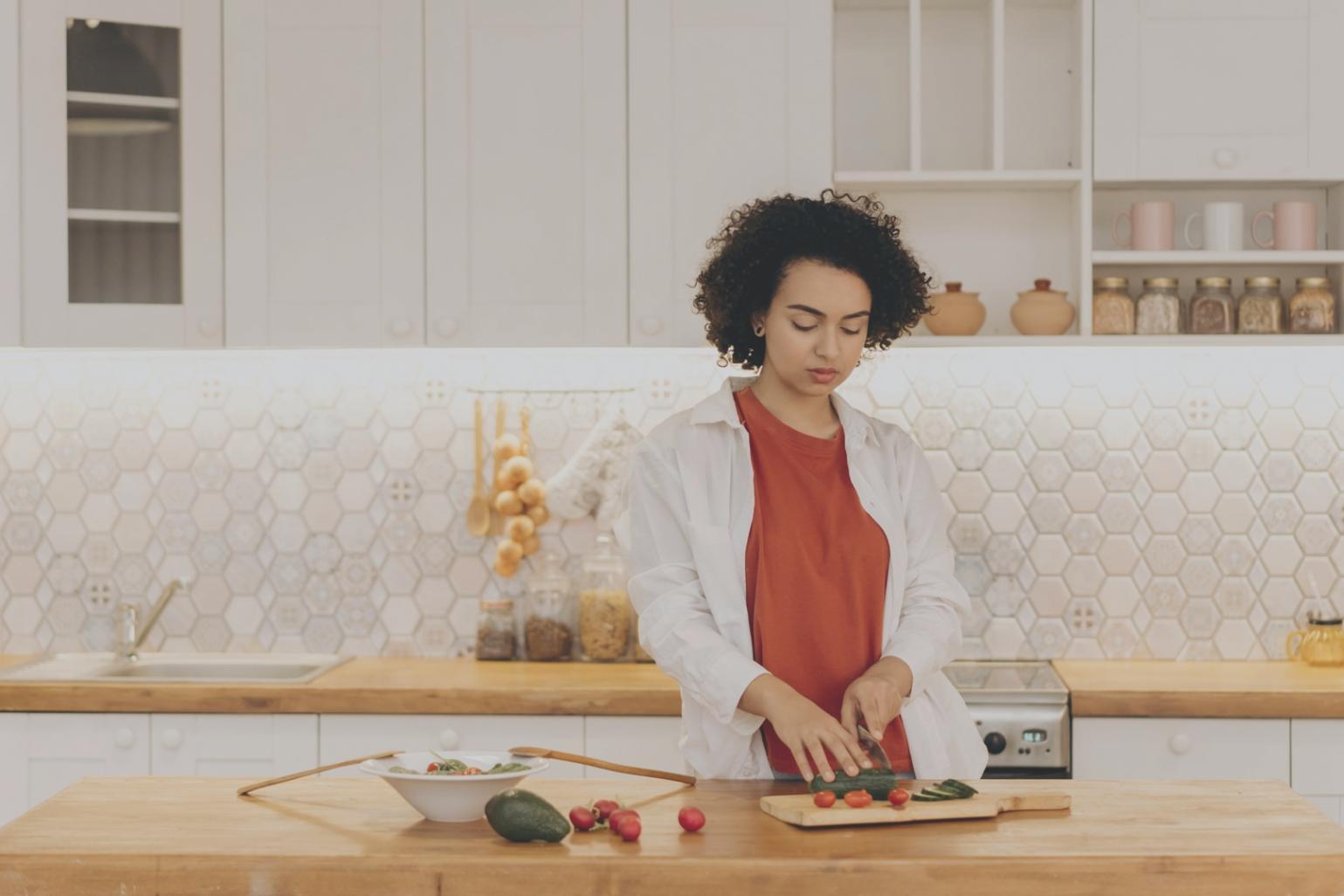 Student carefully piping decorative frosting patterns on a layered cake during hands-on practice session